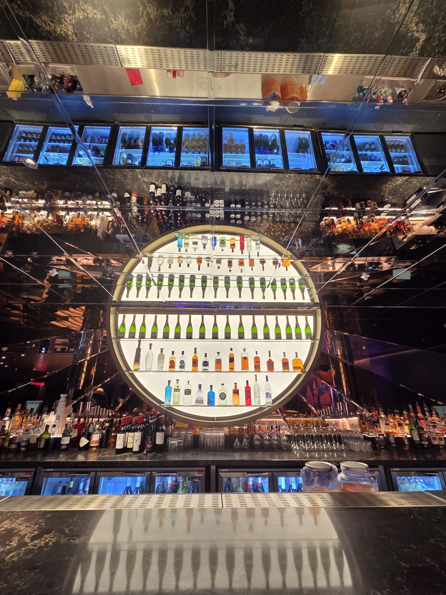 Finished 2.78 metre semicircular champagne display whose mirrored reflection completes the circle at Moxy Hotel Piccadilly