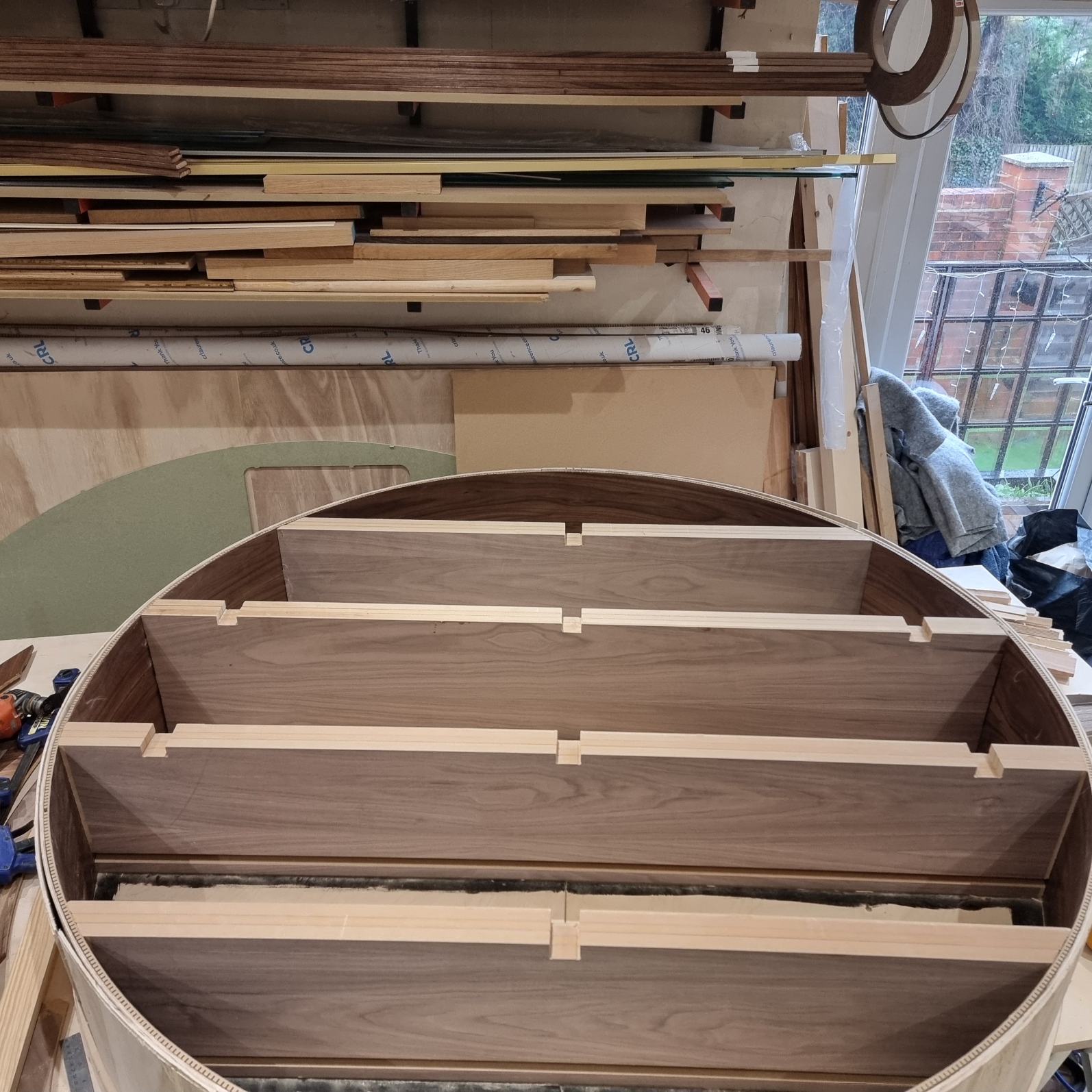 Circular walnut shelving feature being assembled in the workshop