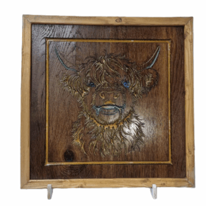 Front view of handcrafted Highland cow wood carving with resin inlay and rustic wooden frame