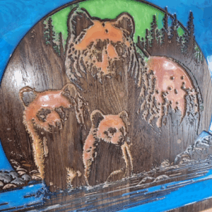 Close-up of mother bear and cubs wood carving