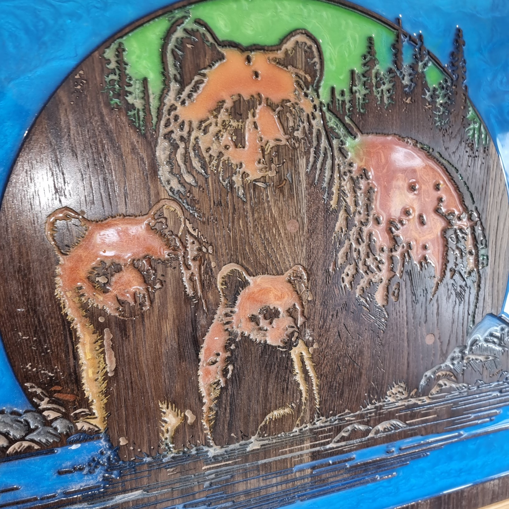 Close-up of mother bear and cubs wood carving