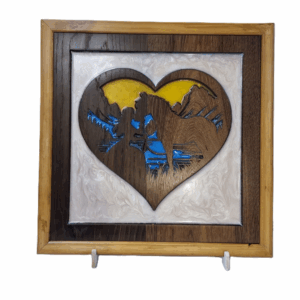 Wooden heart silhouette carving of a girl kissing her horse with blue and yellow resin background
