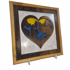 Angled left view of wood and resin heart carving featuring girl and horse