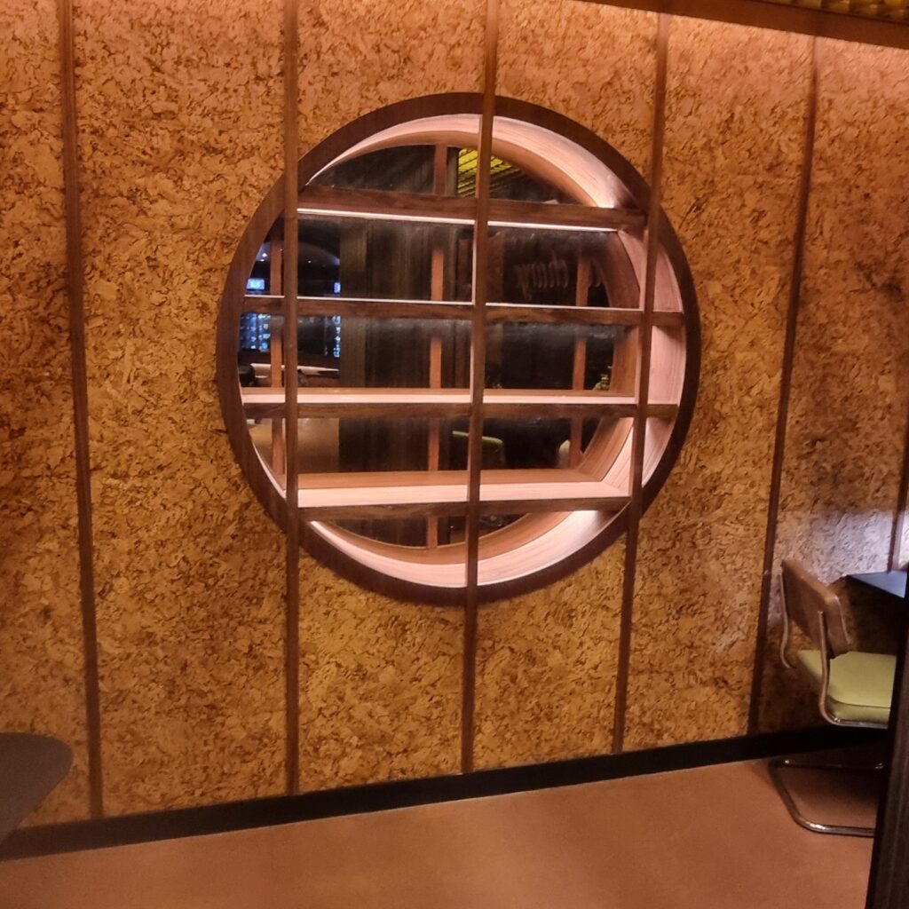 Bespoke circular display joinery feature in plug-in room at Moxy Hotel Piccadilly London by Kustom Made Ltd