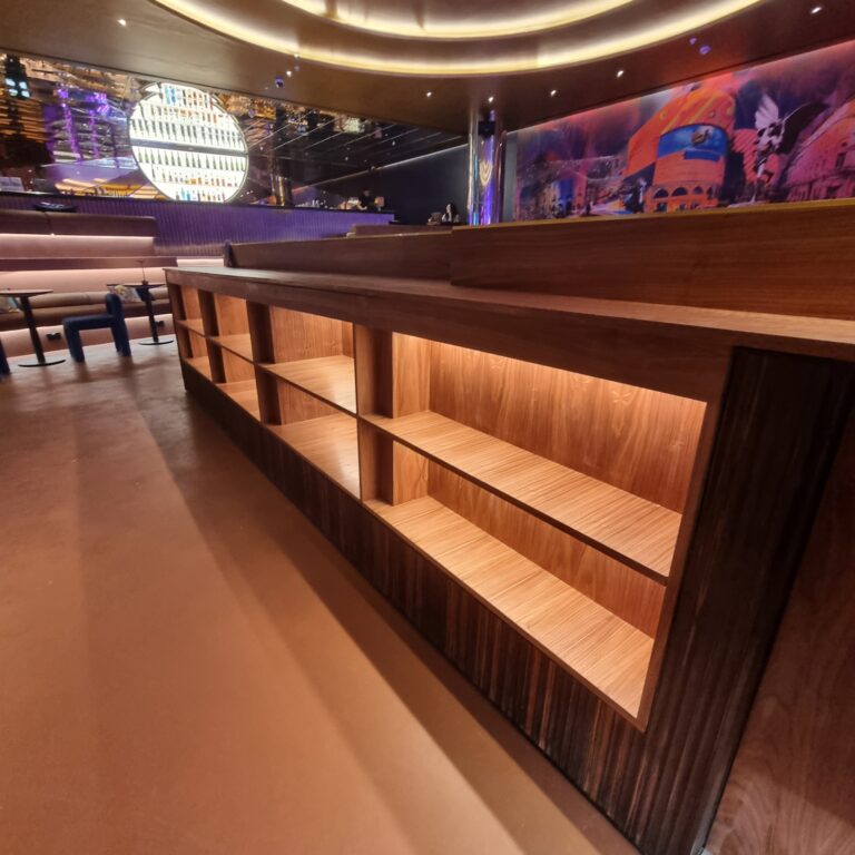 Bespoke walnut bar joinery with Havwoods Ebony Ondato ribbed timber and LED shelving at Moxy Hotel Piccadilly London by Kustom Made Ltd